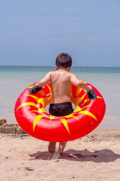 Junge mit Schlauch geht ins Wasser — Stockfoto