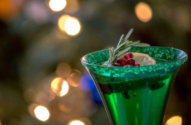 bir limon dilimi, biberiye ve nar tohumu ile yeşil şampanya flüt kadar yakın