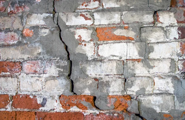 crumbling brick wall with cracks