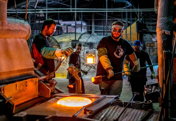 Arbeiter tragen Tiegelkellen aus geschmolzenem Glas — Stockfoto