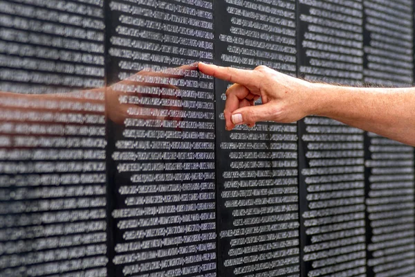 Touching a name on the wall — Stock Photo, Image