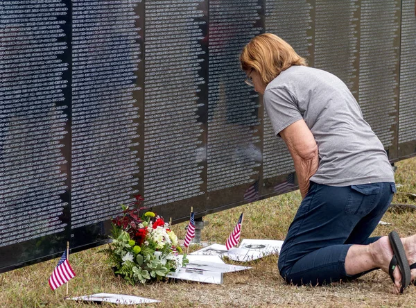 Woman kneels at eh wall that heals — Stock Photo, Image