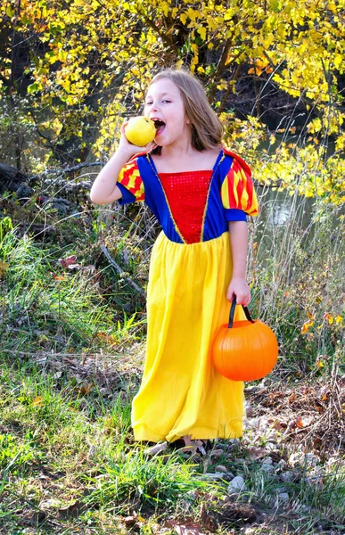 Meisje in een prinses kostuum met een sappige appel — Stockfoto