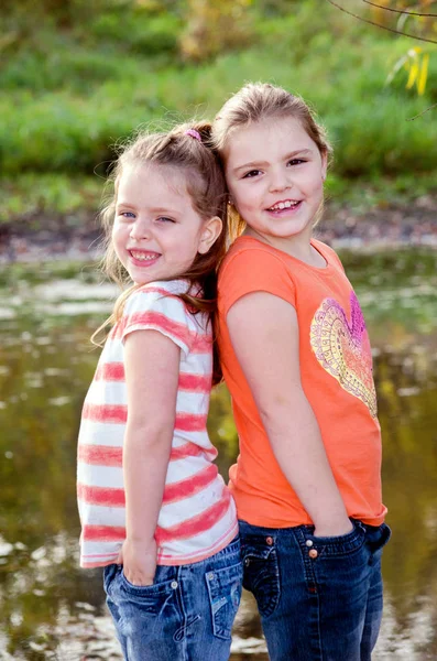 Sisters pose back to back — Stock Photo, Image