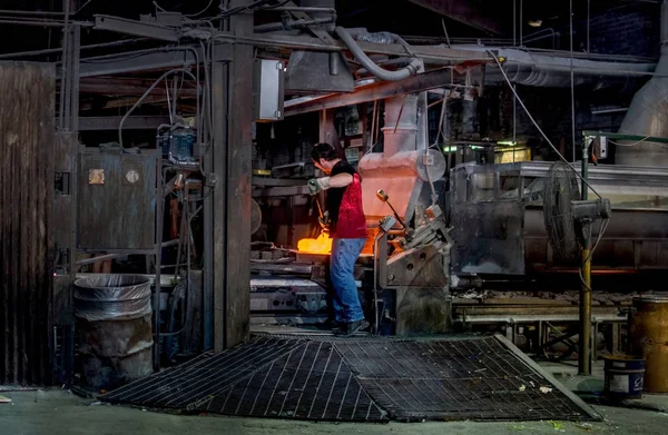 Arbeiter mischt in Glasfabrik geschmolzenes Glas in eine Maschine — Stockfoto