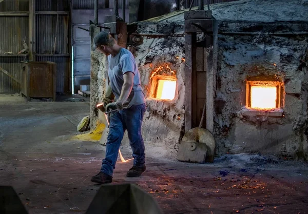 Гаряче скло і працівник на скляній фабриці. — стокове фото