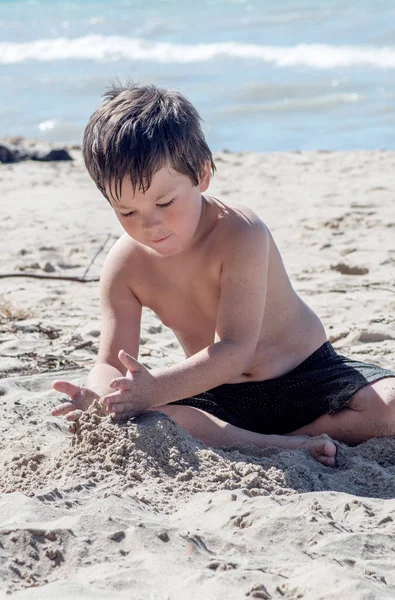 Αγόρι κτίριο με άμμο στην παραλία — Φωτογραφία Αρχείου