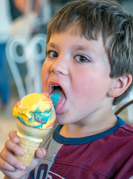 Young boy licking a colorful ice cream cone — ストック写真