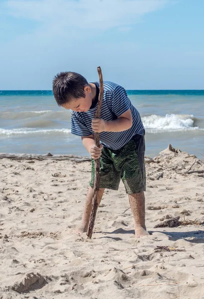 Niño arenoso cavando en la playa — Foto de Stock