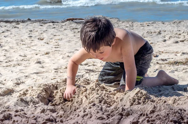 Little boy digging a hole to china — Stock Photo, Image