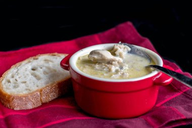 Kırmızı bir peçeteye çorba ve ekmek.