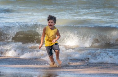 Aktif genç çocuk Michigan Gölü 'ndeki vahşi dalgalardan hızla uzaklaşıyor.