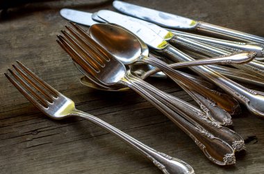 Süslü çatallar, bıçaklar ve kaşıklar masaya konur, akşam yemeği için yayılır.