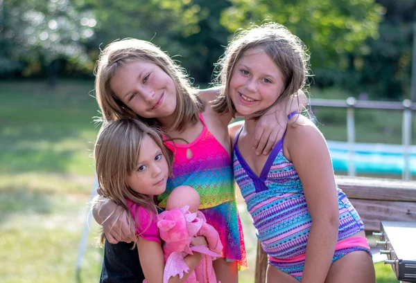 Kolme Nuorta Siskoa Poseeraa Yhdessä Uimapuvuissa Kun Leikkivät Ulkona Kuumina — kuvapankkivalokuva
