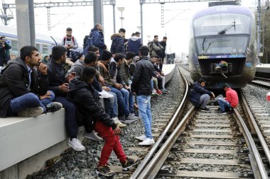 Göçmen aileler tren istasyonu platformunda oturup Atina'daki Larissis tren merkezi istasyonunda bir protesto sırasında hattı kapatmak için rayların üzerinde durmak, Nisan'da Yunanistan 5, 2019.