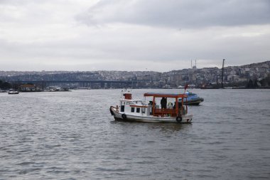 Teknelerdeki Ortodoks Hıristiyanlar, Epifani kutlamaları sırasında Boğaz'a atılan tahta bir haç almak için suya atlamaya hazırlanıyorlar. in İstanbul, Türkiye 6 Ocak 2019