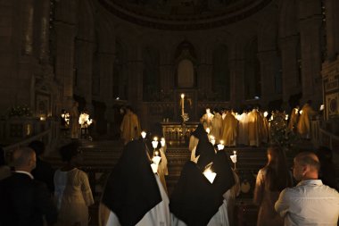 İbadet edenler, 20 Nisan 2019'da Fransa'nın Kutsal Kalbi Bazilikası'nda Paskalya ayini sırasında mum tutuyorlar.
