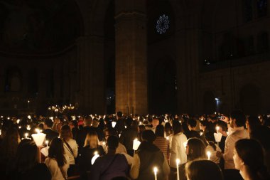 İbadet edenler, 20 Nisan 2019'da Fransa'nın Kutsal Kalbi Bazilikası'nda Paskalya ayini sırasında mum tutuyorlar.