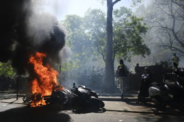 İtfaiyeciler Paris'te Emmanuel Macron politikasına karşı Sarı yelek hareketi tarafından çağrılan bir gösteri sırasında bir sokakta yanan scooter üzerine su püskürtmek, Fransa Nisan'da 20, 2019