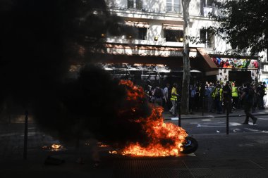 İtfaiyeciler Paris'te Emmanuel Macron politikasına karşı Sarı yelek hareketi tarafından çağrılan bir gösteri sırasında bir sokakta yanan scooter üzerine su püskürtmek, Fransa Nisan'da 20, 2019
