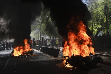 İtfaiyeciler Paris'te Emmanuel Macron politikasına karşı Sarı yelek hareketi tarafından çağrılan bir gösteri sırasında bir sokakta yanan scooter üzerine su püskürtmek, Fransa Nisan'da 20, 2019