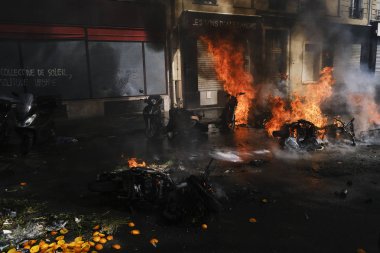İtfaiyeciler Paris'te Emmanuel Macron politikasına karşı Sarı yelek hareketi tarafından çağrılan bir gösteri sırasında bir sokakta yanan scooter üzerine su püskürtmek, Fransa Nisan'da 20, 2019