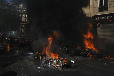 İtfaiyeciler Paris'te Emmanuel Macron politikasına karşı Sarı yelek hareketi tarafından çağrılan bir gösteri sırasında bir sokakta yanan scooter üzerine su püskürtmek, Fransa Nisan'da 20, 2019