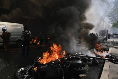 İtfaiyeciler Paris'te Emmanuel Macron politikasına karşı Sarı yelek hareketi tarafından çağrılan bir gösteri sırasında bir sokakta yanan scooter üzerine su püskürtmek, Fransa Nisan'da 20, 2019