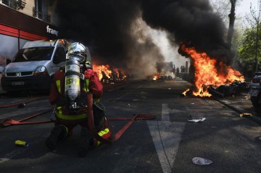 İtfaiyeciler Paris'te Emmanuel Macron politikasına karşı Sarı yelek hareketi tarafından çağrılan bir gösteri sırasında bir sokakta yanan scooter üzerine su püskürtmek, Fransa Nisan'da 20, 2019