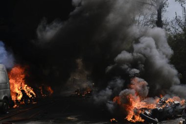 İtfaiyeciler Paris'te Emmanuel Macron politikasına karşı Sarı yelek hareketi tarafından çağrılan bir gösteri sırasında bir sokakta yanan scooter üzerine su püskürtmek, Fransa Nisan'da 20, 2019