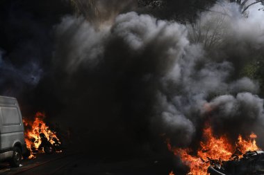 İtfaiyeciler Paris'te Emmanuel Macron politikasına karşı Sarı yelek hareketi tarafından çağrılan bir gösteri sırasında bir sokakta yanan scooter üzerine su püskürtmek, Fransa Nisan'da 20, 2019