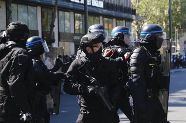 French riot police clash with French yellow vests protesters during a demonstration called by the Yellow vest movement against the policy of Emmanuel Macron  in Paris, France on Apr. 20, 2019 clipart