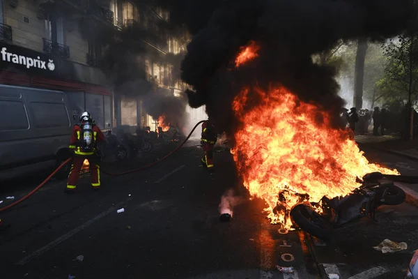 消防士は 2019年4月20日にフランスのパリでエマニュエル マクロンの政策に反対するイエローベスト運動によって呼び出されたデモの間 路上で燃えているスクーターに水を吹きかけました — ストック写真