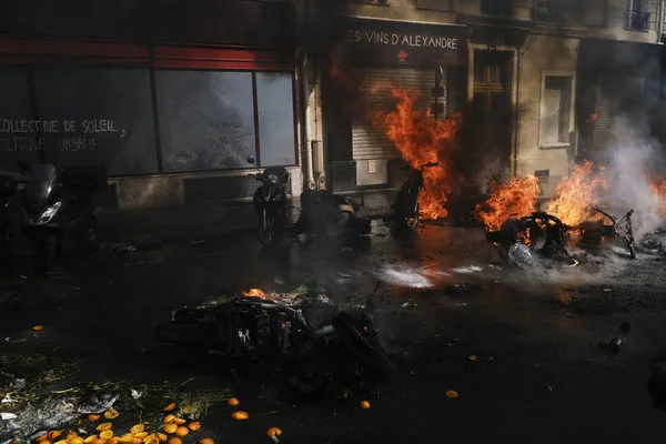 消防士は 2019年4月20日にフランスのパリでエマニュエル マクロンの政策に反対するイエローベスト運動によって呼び出されたデモの間 路上で燃えているスクーターに水を吹きかけました — ストック写真