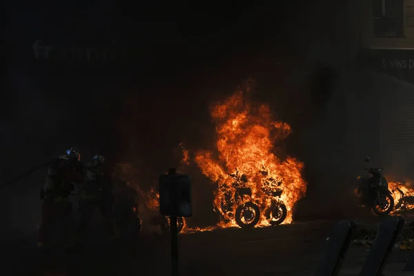 消防士は 2019年4月20日にフランスのパリでエマニュエル マクロンの政策に反対するイエローベスト運動によって呼び出されたデモの間 路上で燃えているスクーターに水を吹きかけました — ストック写真