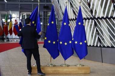 Brüksel, Belçika. 28 Mayıs 2019.An yetkilisi, Avrupa Birliği Zirvesi sırasında Avrupa Konseyi binasının lobisinde bir Avrupa Birliği bayrağı nı ayarlıyor.