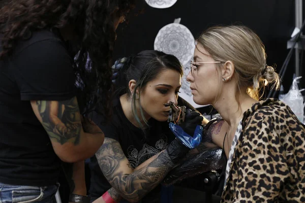 stock image Brussels, Belgium. Nov. 11th, 2018. A Tattoo artist  tattooed a person during the International Brussels Tattoo Convention. 