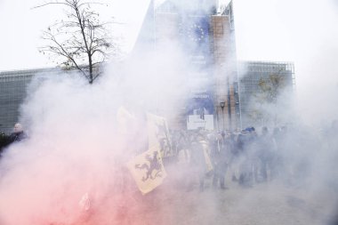 16 Aralık 2018'de Belçika'nın başkenti Brüksel'de Marakeş Göç Paktı'nı protesto eden aşırı sağcı destekçiler, Flanders bayrağını sallıyor.