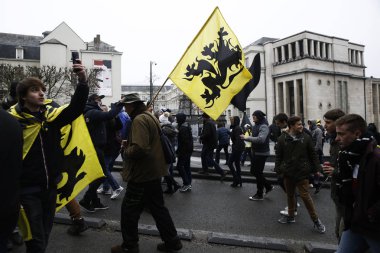 16 Aralık 2018'de Belçika'nın başkenti Brüksel'de Marakeş Göç Paktı'nı protesto eden aşırı sağcı destekçiler, Flanders bayrağını sallıyor.