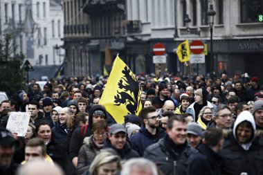 16 Aralık 2018'de Belçika'nın başkenti Brüksel'de Marakeş Göç Paktı'nı protesto eden aşırı sağcı destekçiler, Flanders bayrağını sallıyor.