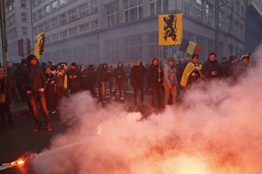16 Aralık 2018'de Belçika'nın başkenti Brüksel'de Marakeş Göç Paktı'nı protesto eden aşırı sağcı destekçiler, Flanders bayrağını sallıyor.
