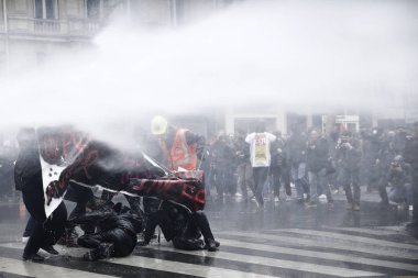 Polis, 22 Mart 2018'de Paris'te Fransız hükümetinin reform dizisini protesto eden göstericilere karşı su kanonu kullanıyor. 