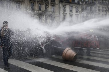Polis, 22 Mart 2018'de Paris'te Fransız hükümetinin reform dizisini protesto eden göstericilere karşı su kanonu kullanıyor. 