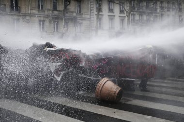 Polis, 22 Mart 2018'de Paris'te Fransız hükümetinin reform dizisini protesto eden göstericilere karşı su kanonu kullanıyor. 