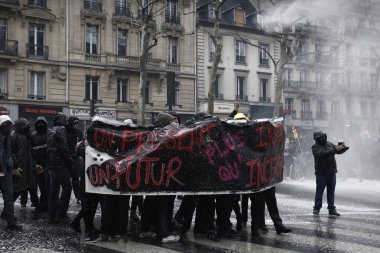 Polis, 22 Mart 2018'de Paris'te Fransız hükümetinin reform dizisini protesto eden göstericilere karşı su kanonu kullanıyor. 