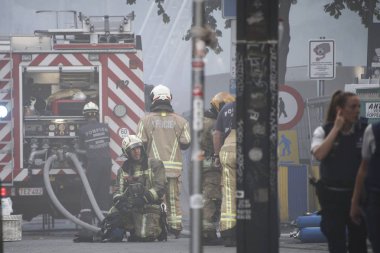  İtfaiyeciler bir yapıda çıkan yangını söndürmeye çalışıyor