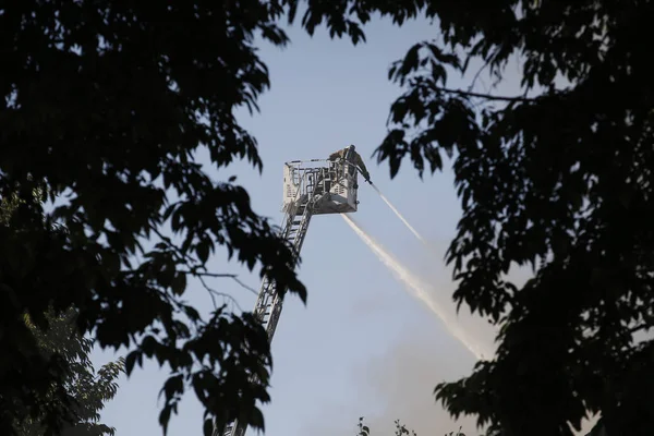 Bomberos tratan de extinguir un incendio que estalló en una construcción —  Fotos de Stock