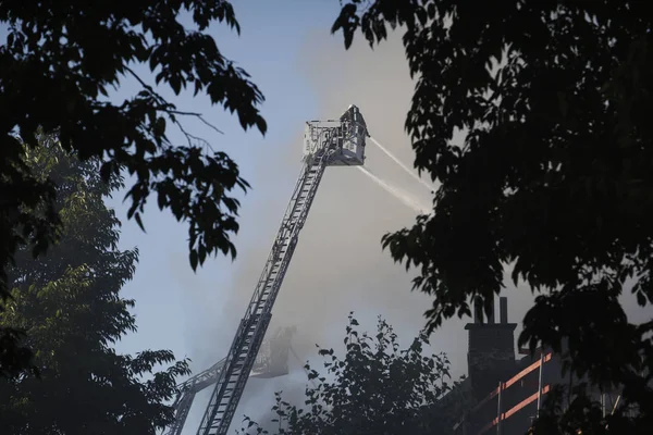 I vigili del fuoco cercano di spegnere un incendio scoppiato in un edificio — Foto Stock