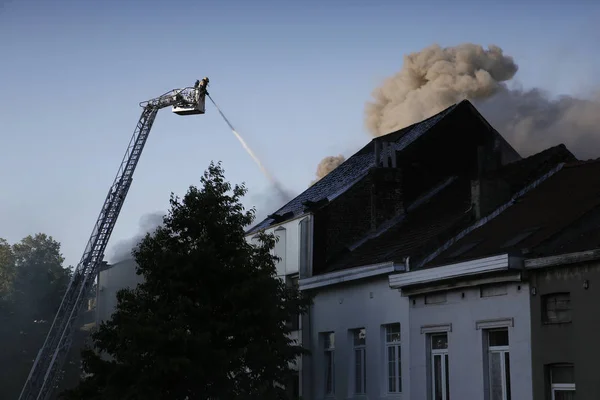 Пожарные пытаются потушить пожар, который вспыхнул в здании — стоковое фото