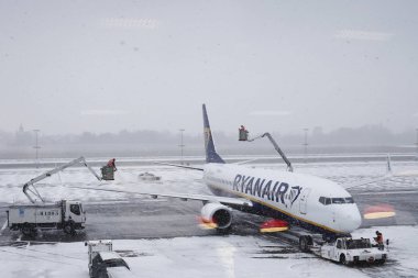 Airplanes on the runway are covered by snow during a snowfall at clipart